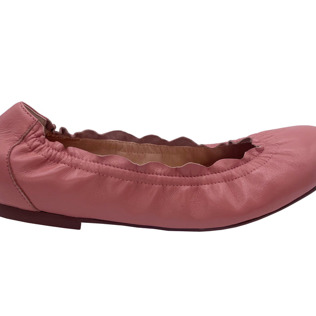 A salmon leather ballet flat with a scalloped edge and comfortable rubber sole.