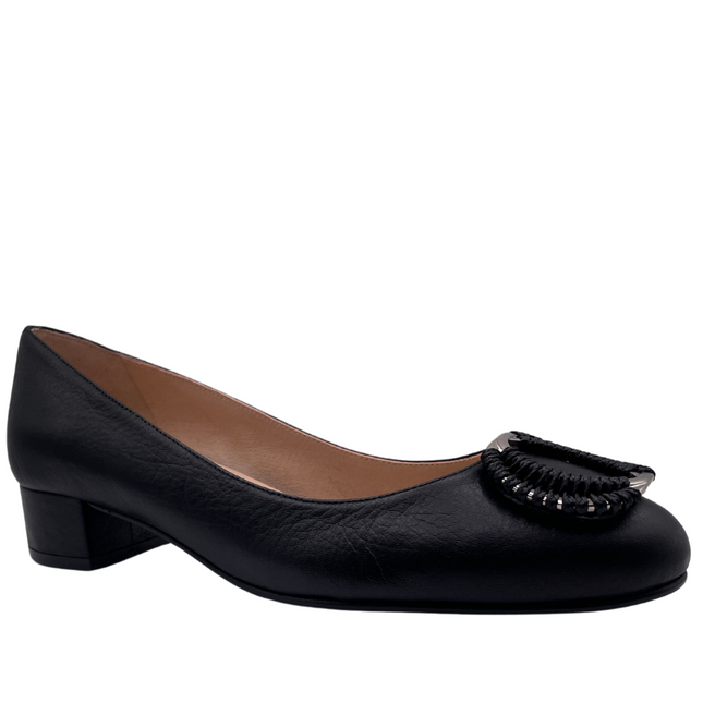 Black leather pump with a rounded toe, block heel, and a silver buckle wrapped in black detailing on the toe box ANGLE VIEW 
