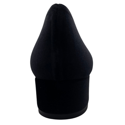 Black velvet pump with a rounded toe, block heel, and a silver buckle wrapped in black detailing on the toe box back view 