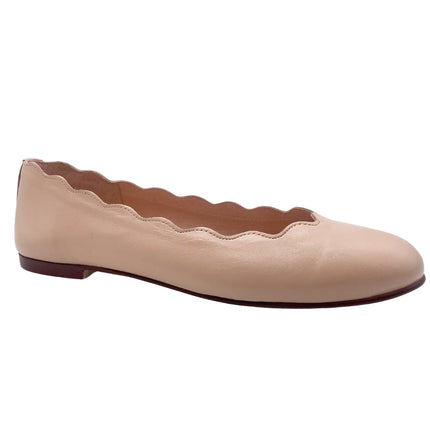 beige leather ballet flat with a rounded toe and scalloped edge along the topline angle view 