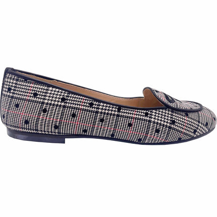 A flat shoe with a black and white plaid pattern and a cushioned leather footbed.