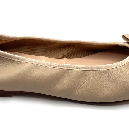 Beige leather ballet flat with a rounded toe and a large folded bow accent on the front. Side view