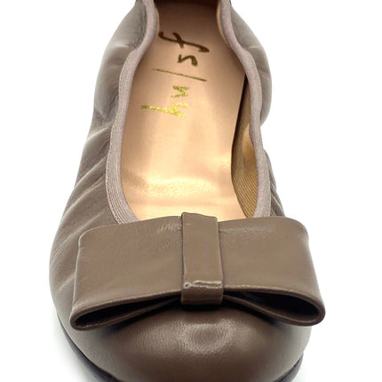 Taupe leather ballet flat with a rounded toe and a large folded bow accent on the front. Front View