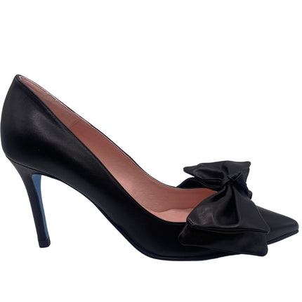 A black leather heel with a pointed toe and an oversized bow on the top.