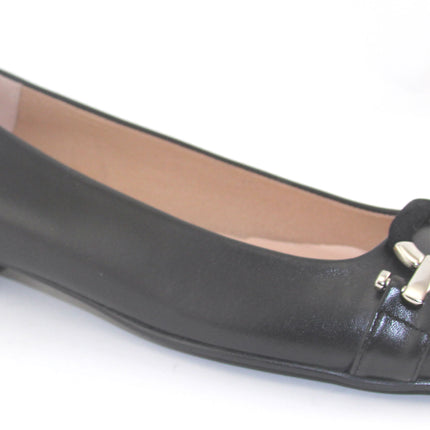 Black leather flat with a square toe, a small heel for slight lift, and a textured black buckle with silver detailing on the toe box angle view 