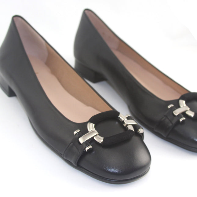 Black leather flat with a square toe, a small heel for slight lift, and a textured black buckle with silver detailing on the toe box both shoes 