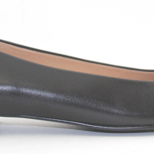 Black leather flat with a square toe, a small heel for slight lift, and a textured black buckle with silver detailing on the toe box side view 
