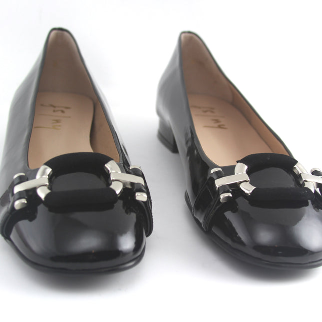 Black leather flat with a square toe, a small heel for slight lift, and a textured black buckle with silver detailing on the toe box full pair 