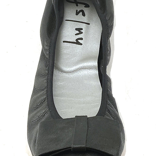 black metallic leather ballet flat with a rounded toe and a large folded bow accent on the front. top view 