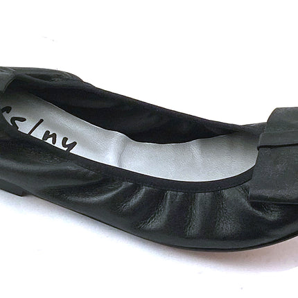 black metallic leather ballet flat with a rounded toe and a large folded bow accent on the front. angle view 