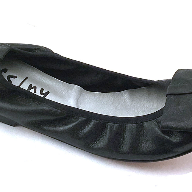 black metallic leather ballet flat with a rounded toe and a large folded bow accent on the front. angle view 