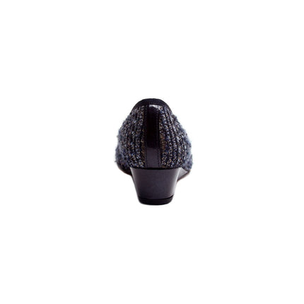 Black wedge shoe with a textured tweed-style upper, glossy patent cap toe, and a small bow on the front. back view 